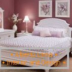 Бузковий інтер'єр спальні з білими меблями