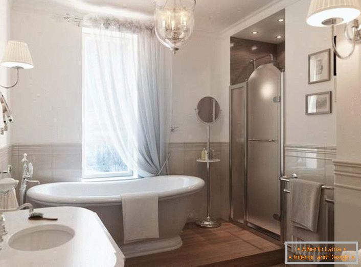 Велика керамічна білосніжна ванна стає родзинкою інтер'єру кімнати. Вікно завешено напівпрозорої спадаючої фіранкою з натуральної тканини, що повністю відповідає стилю модерн.