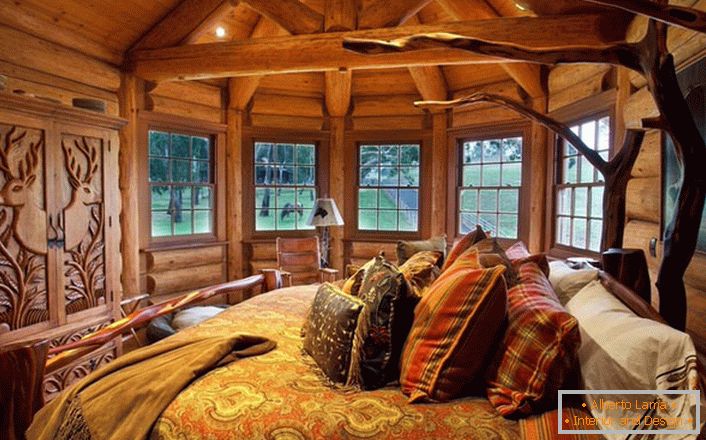 Одна з спальних кімнат в будинку у озері виконана в стилі сільський кантрі. Дерев'яна обробка. масивні меблі і елементи декору підібрані в кращих традиціях стилю.