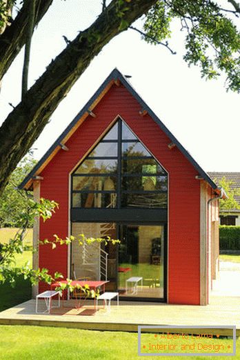 Інтер'єр маленького дерев'яного будинку з великими вікнами