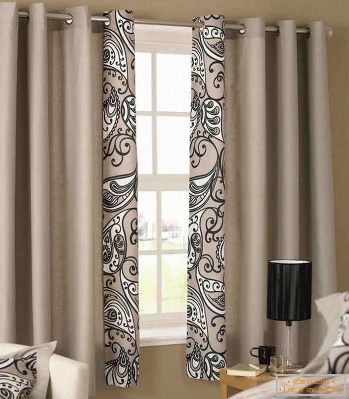 Стильні короткі штори світло-пурпурного кольору повторюють узор, яким оздоблено постільна білизна в спальні в стилі модерн.