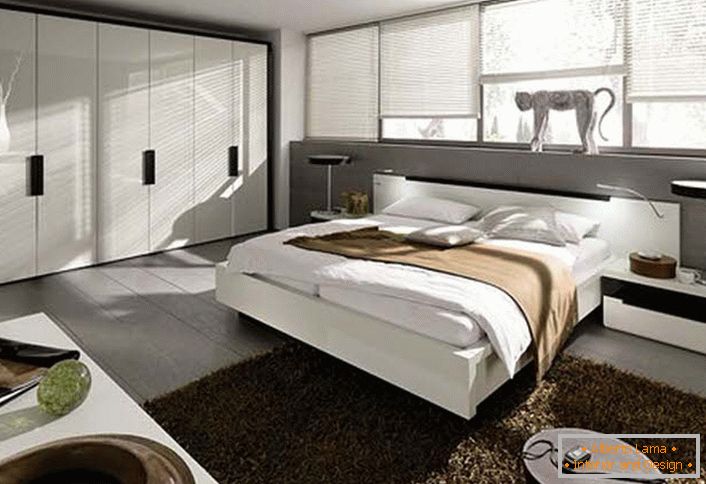 Сімейна спальня в стилі модерн. Для спальної кімнати була грамотно підібрана меблі. Стіну в узголів'я ліжка повністю займають вікна однакового розміру.
