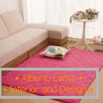 Рожевий килим біля білого дивана
