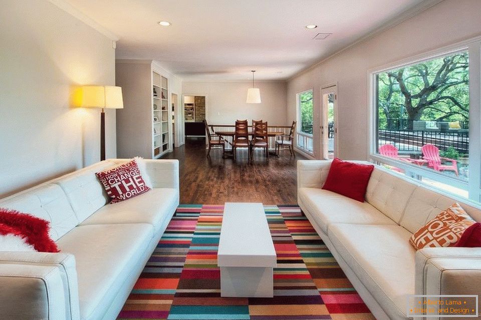 Вітальня з білими диванами і кольоровим килимом
