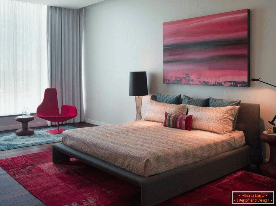 Бордовий килим, крісло і картина в спальні