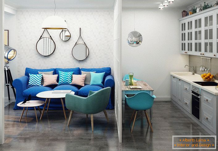 Темно-синій диван контрастно виглядає на тлі світлої обробки. Приклад вдалого оформлення невеликої однокімнатної квартири.
