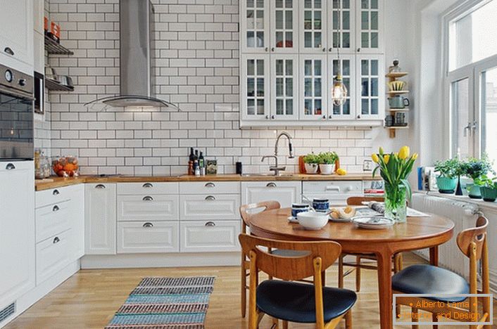 Інтер'єр кухні виконаний в скандинавському стилі, який виражений білої, спокійною гамою оформлення. 