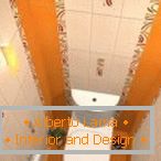 Поєднання білої і помаранчевої плитки в оформленні туалету