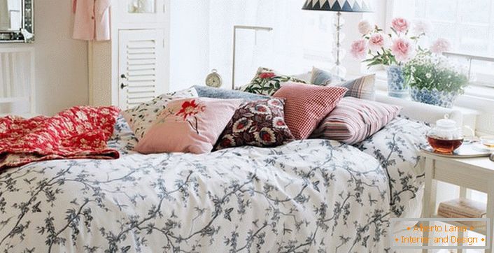 Правильно декорована в стилі кантрі ліжко. У кращих традиціях кантрі на спальному місці складені подушки контрастних кольорів і плед.