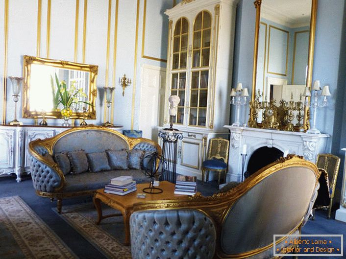 Вітальня в ампір стилі виконана в ніжно-блакитних тонах, які гармонійно поєднуються з золотими елементами декору. Обрамлення дзеркал і різьблені елементи меблів виконані в єдиному стилі.