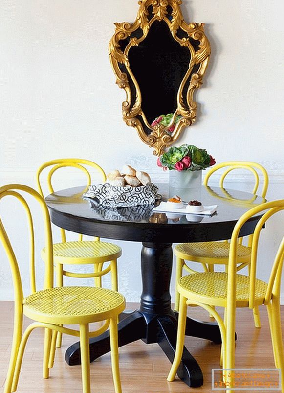 Яскраві жовті стільці і чорний обідній стіл