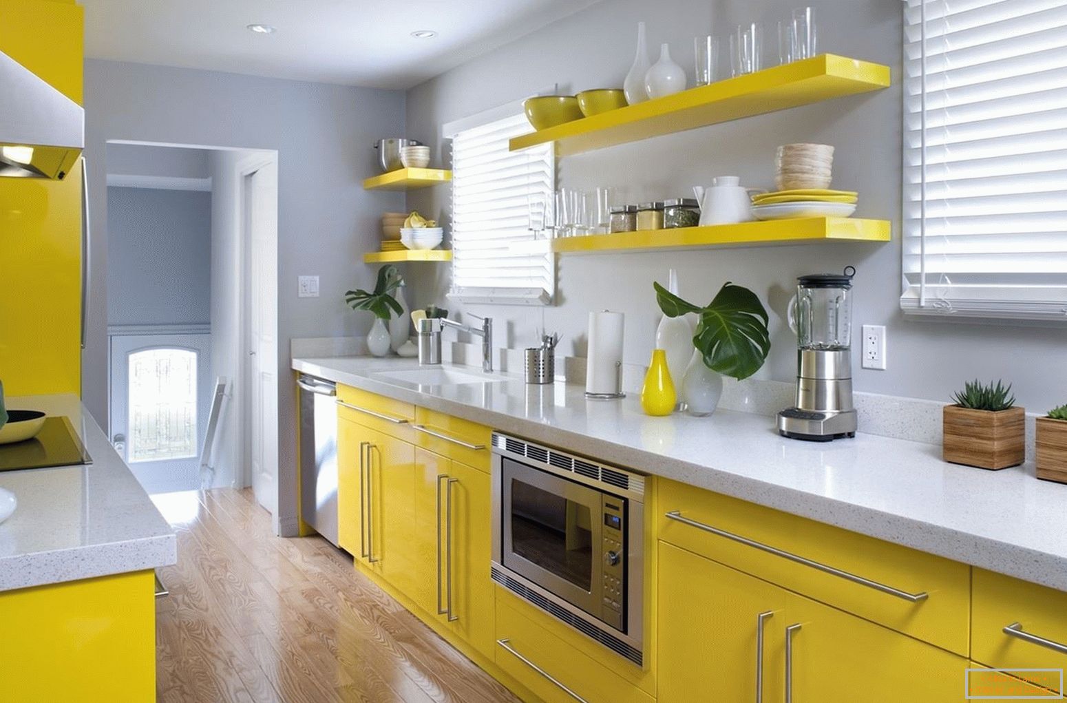 Поєднання жовтого меблів і сірих стін на кухні