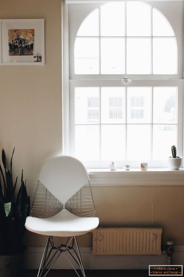 Білий стілець біля великого вікна