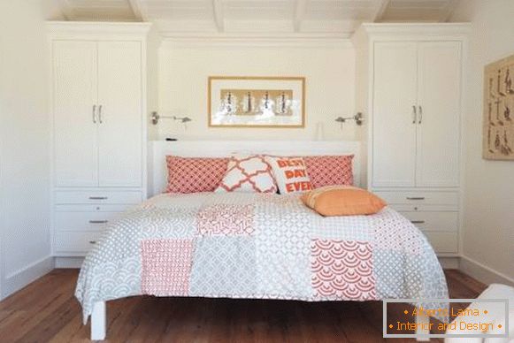 Білі меблі для спальні з червоним і бежевим декором