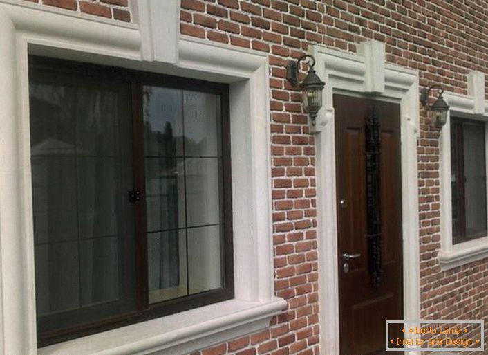 Цегляна кладка органічно поєднується з фасадною ліпниною, що обрамляє віконні та дверні прорізи.