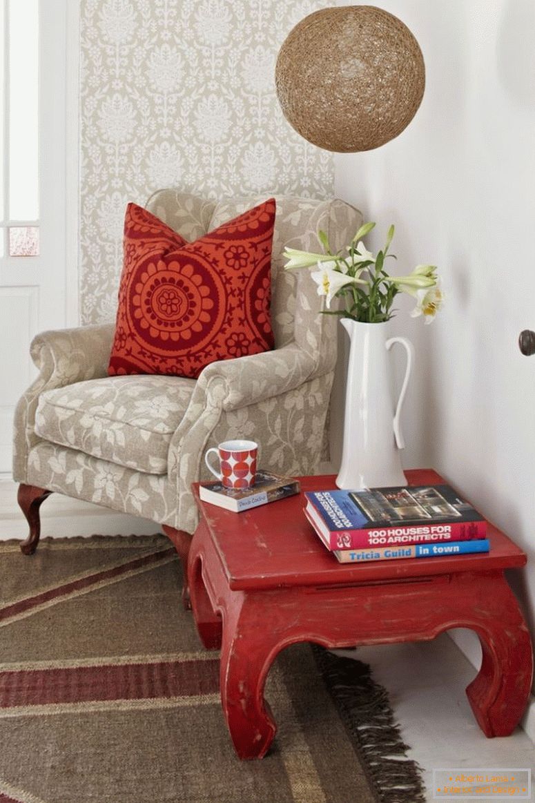 Читальний кут; опіум-стіл і бліде крісло з малюнком розкиданих подушків проти шпалерної стінки