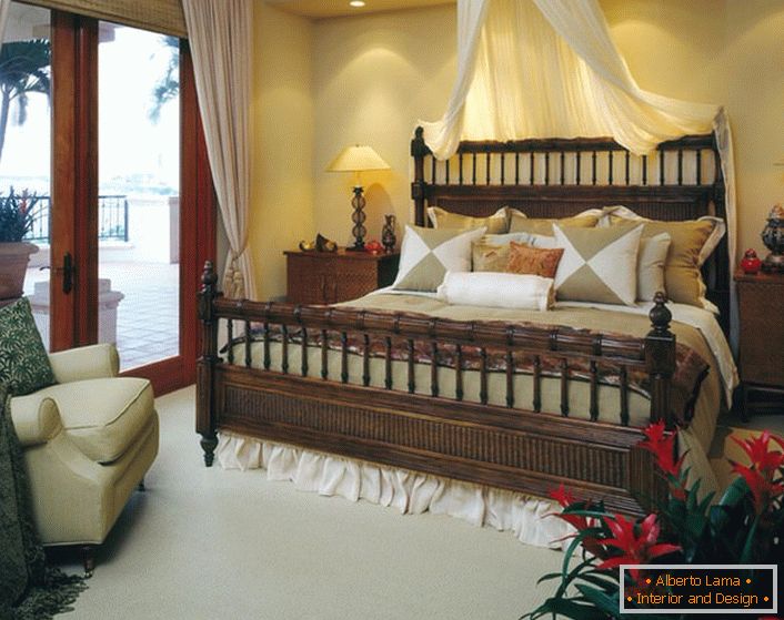 Розкішне ліжко в спальні в стилі еклектика. Балдахін над ліжком, легкі штори на дверях, що ведуть на веранду, роблять приміщення затишним і романтичним. 