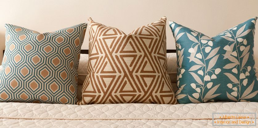 Декоративні подушки на ліжку в пастельно-бірюзових тонах