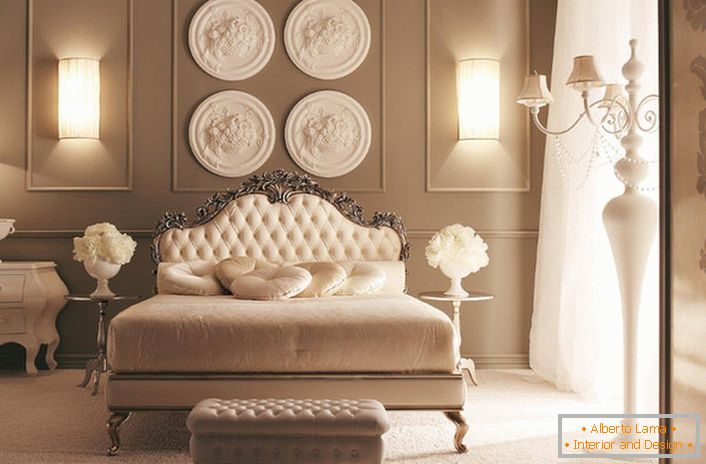 В узголів'я ліжка стіна прикрашена композицією з дизайнерської ліпнини. Вишукана прикраса спальні в стилі арт-деко.