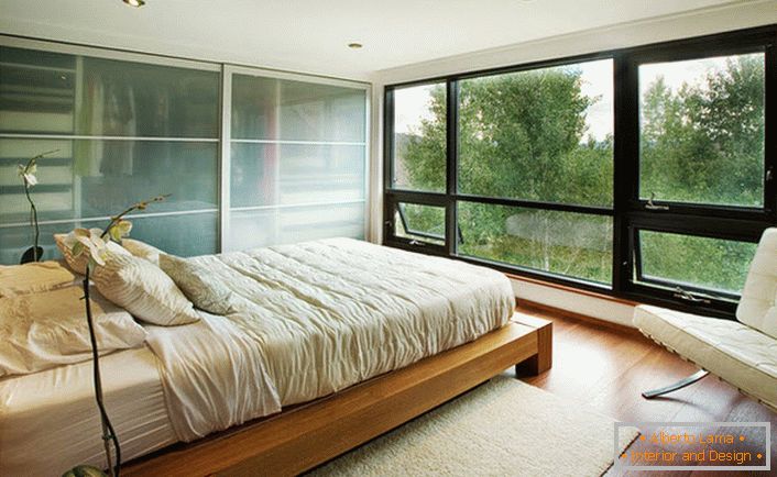 Низька ліжко з дерева гармонійно вписується в інтер'єр спальні в стилі модерн.