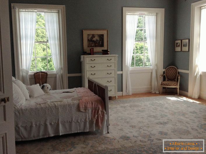Спальня в стилі модерн з правильно організованими віконними прорізами. Легкі, повітряні завіси пропускаю сонячний колір в кімнату.