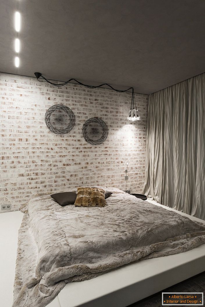 Спальня в лофт стилі повинна містити в своєму інтер'єрі мінімум меблів. Вдалий вибір для даної концепції стилю - велика м'яке ліжко на низькому подіумі.