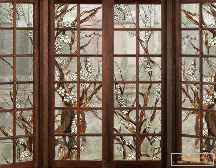 Вікна в темній дерев'яній рамі прикрашені вітражної плівкою. Нехитрий малюнок підійде для оформлення інтер'єру в стилі кантрі або модерн.