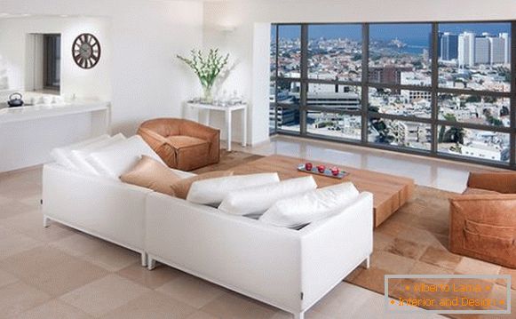 Білий диван навпроти панорамного вікна