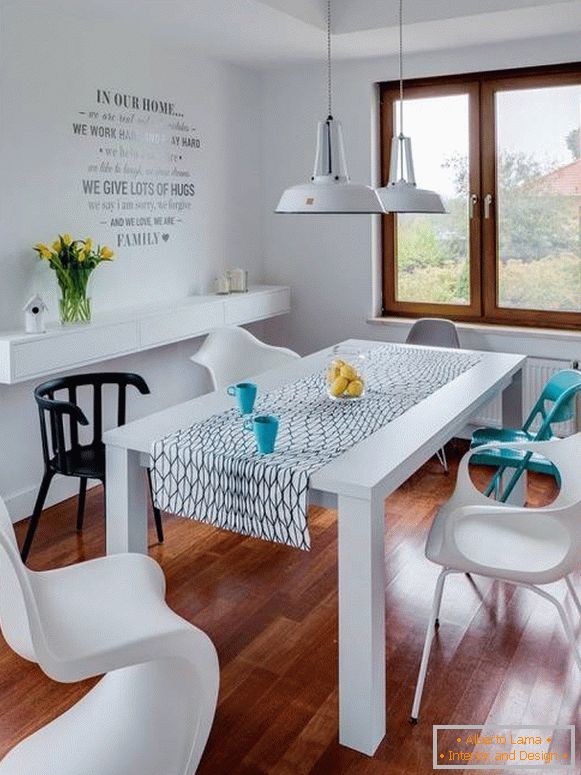 Білий обідній стіл і різнокольорові стільці