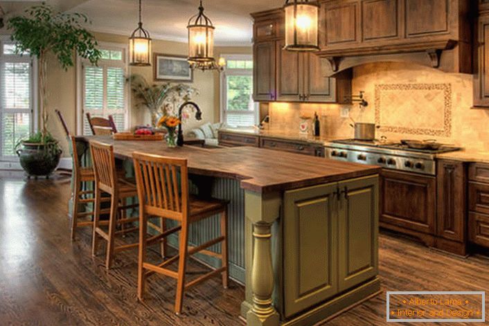 Велика кухня в стилі кантрі з масивними дерев'яними меблями. Відмінне поєднання кольорів - оливкового і темно-коричневого.