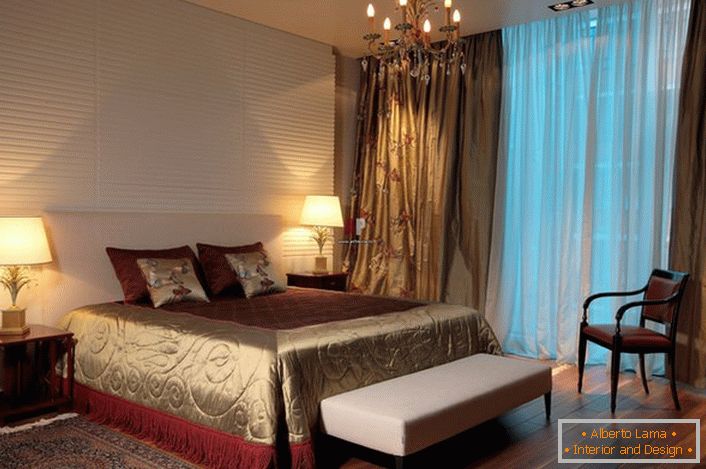 Традиційне висвітлення спальники в класичному стилі-люстра і звичні плафони з боків ліжка. 