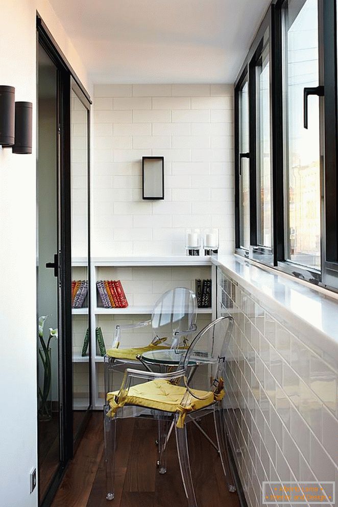 Стільці та столик на невеликому балконі, обробленому білою плиткою