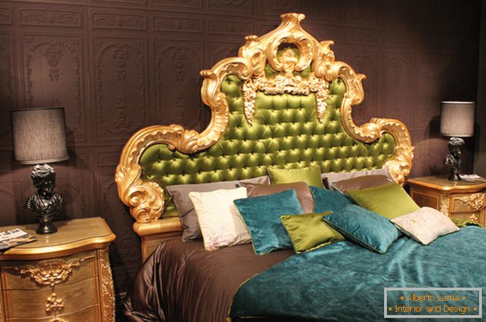 Основним елементом, який притягує погляд, є висока спинка ліжка, оббита шовком зеленого кольору, в золотий різьбленій рамі.