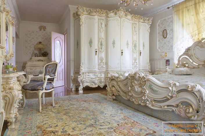 Білосніжна спальна кімната з різьбленою масивними меблями з дерева. Ліжко з високою спинкою в головах, шикарно вписується в інтер'єр в стилі бароко.