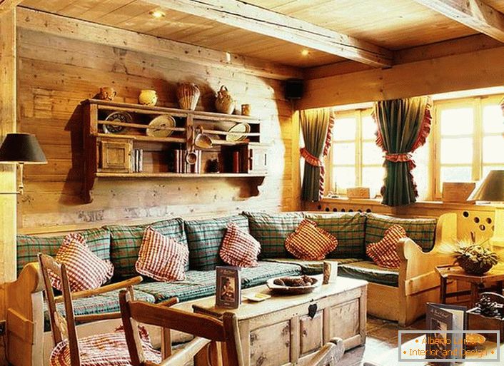 Дерев'яна обробка стін, контрастні подушки на м'якому дивані, щільні фіранки з рюшами на вікнах. Затишна вітальня в сільському стилі в заміському будиночку.