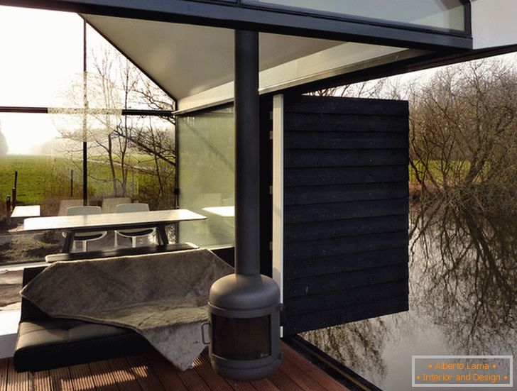 Тераса маленького скляного будиночка біля озера в Голландії