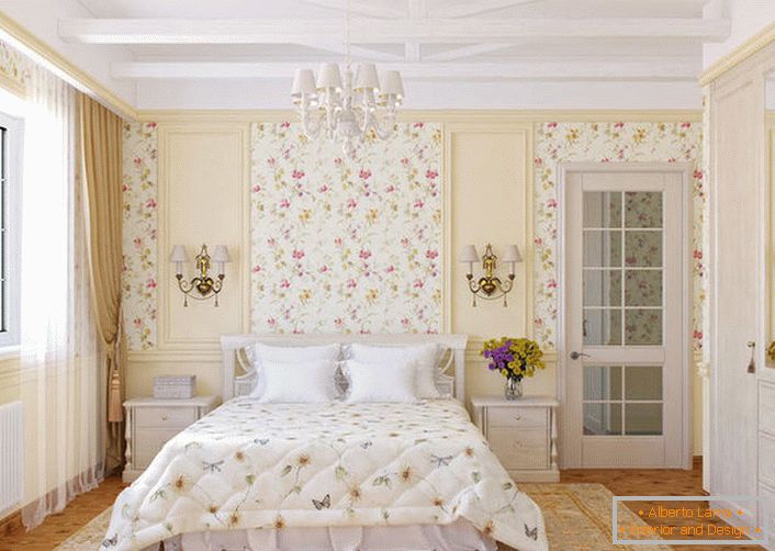 Стіни спальної кімнати в стилі кантрі прикрашені квітковими шпалерами, які гармонійно поєднуються з покривалом на ліжку.