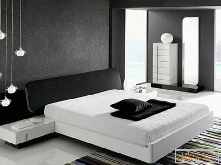 Стіна біля ліжка, декорована сірої матовою вставкою, відповідно до стилю хай-тек гармонує з глянцевим білим підлогою.