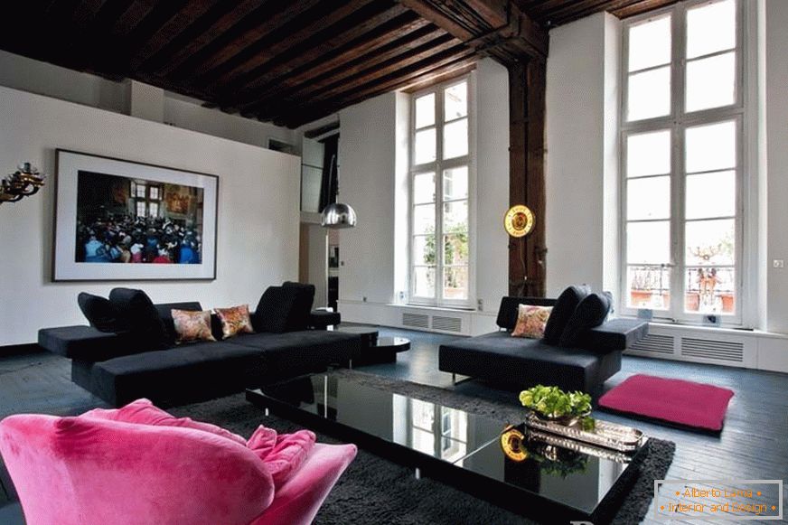 Чорні дивани та рожеве крісло в кімнаті