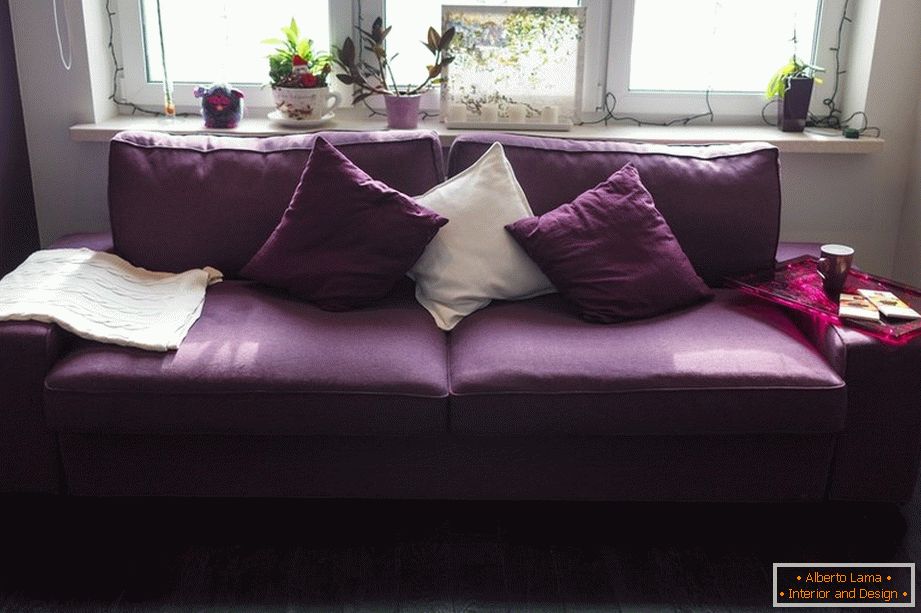 Фіолетовий диван з подушками