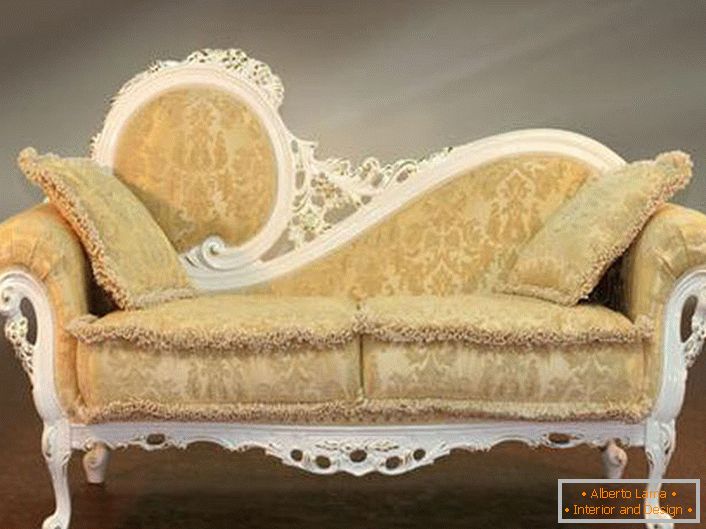 Різьблена спинка дивана і ніжно-бежева оббивка з ледь помітним орнаментом в кращих традиціях бароко.