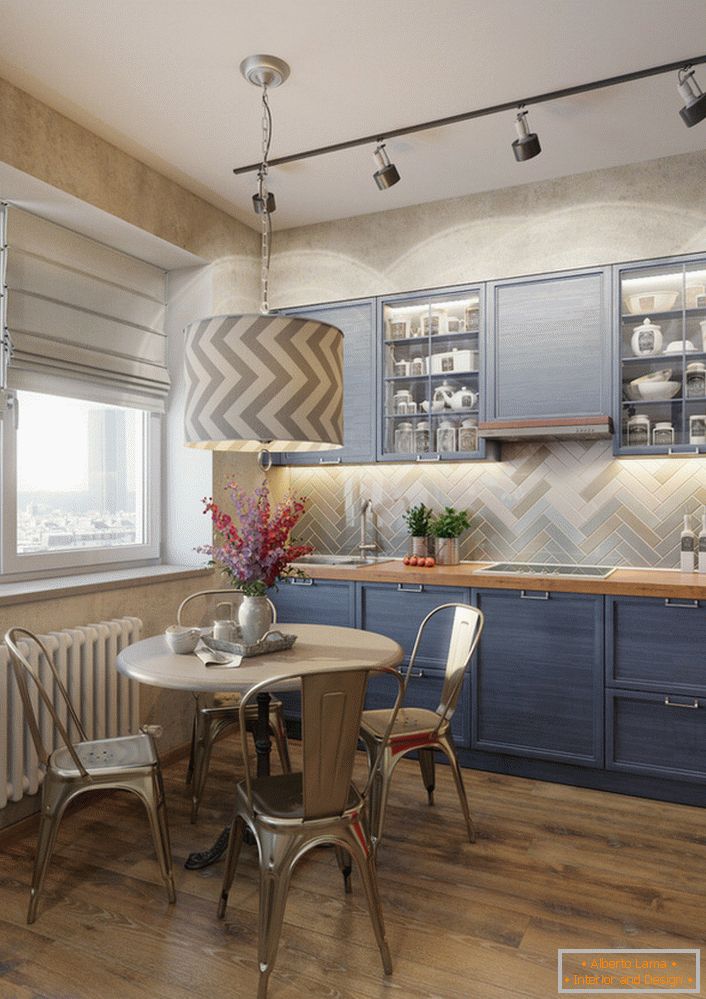 Блідо-синій колір кухонного гарнітура - відмінне рішення для кухні в стилі еклектика. Приклад відмінно підібраного освітлення, яке окремо висвітлює робочу зону і обідній стіл.