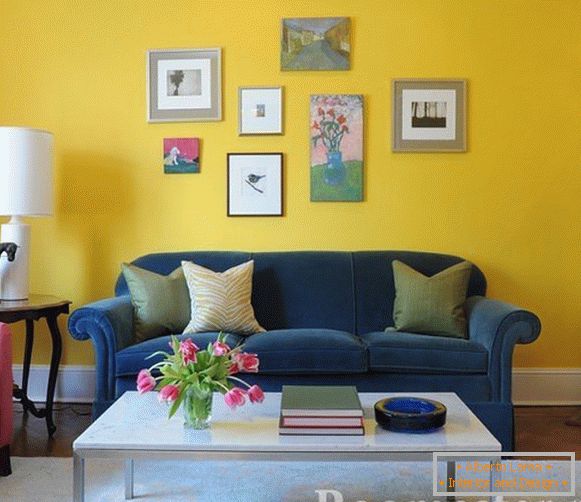 Синій диван на тлі жовтої стіни