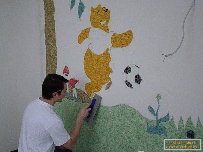 Чоловік малює Віні-Пуха на стіні в дитячій